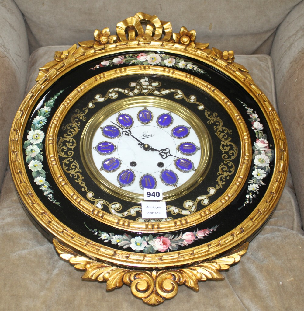 An ornate floral painted circular wall clock